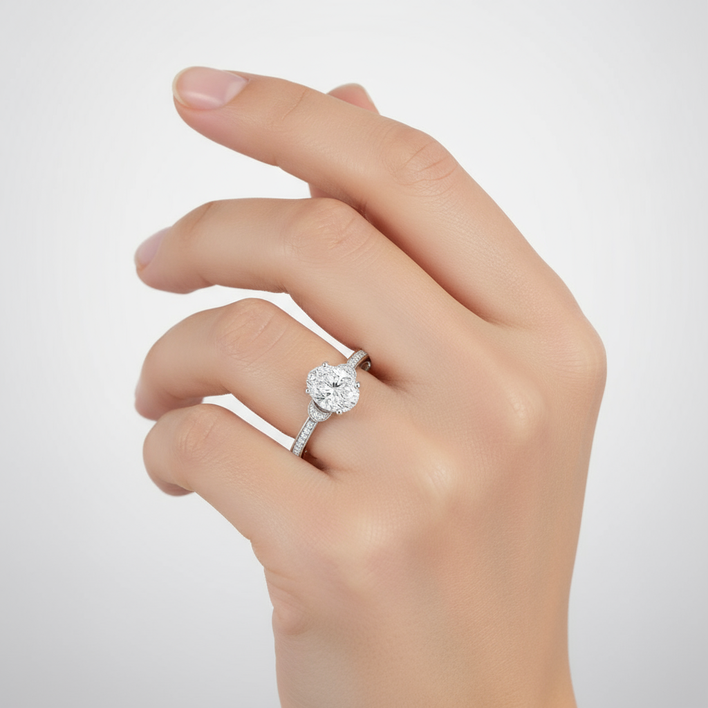 Female model wearing oval diamond engagement ring with pavé half-moon accents