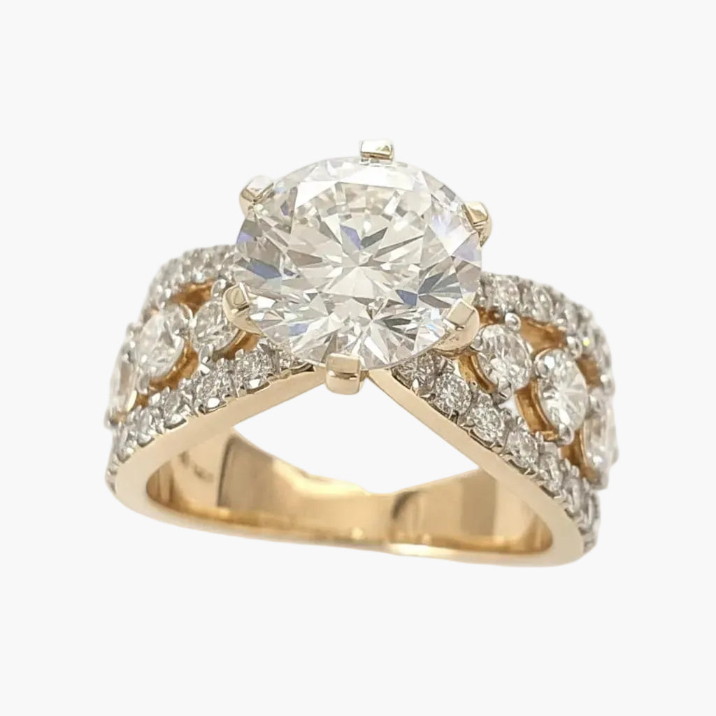 Gold ring with a large diamond and smaller diamonds on a white background