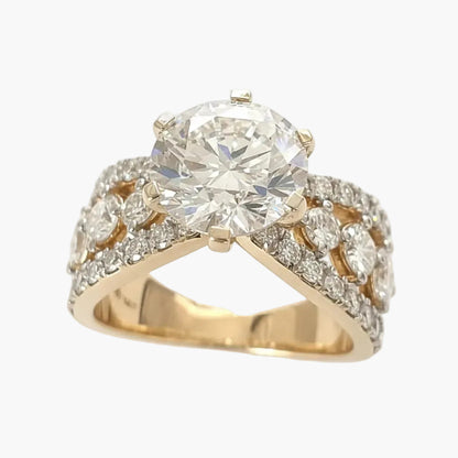 Gold ring with a large diamond and smaller diamonds on a white background