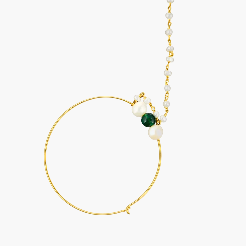 Gold hoop earring with pearls and a green gemstone on a white background