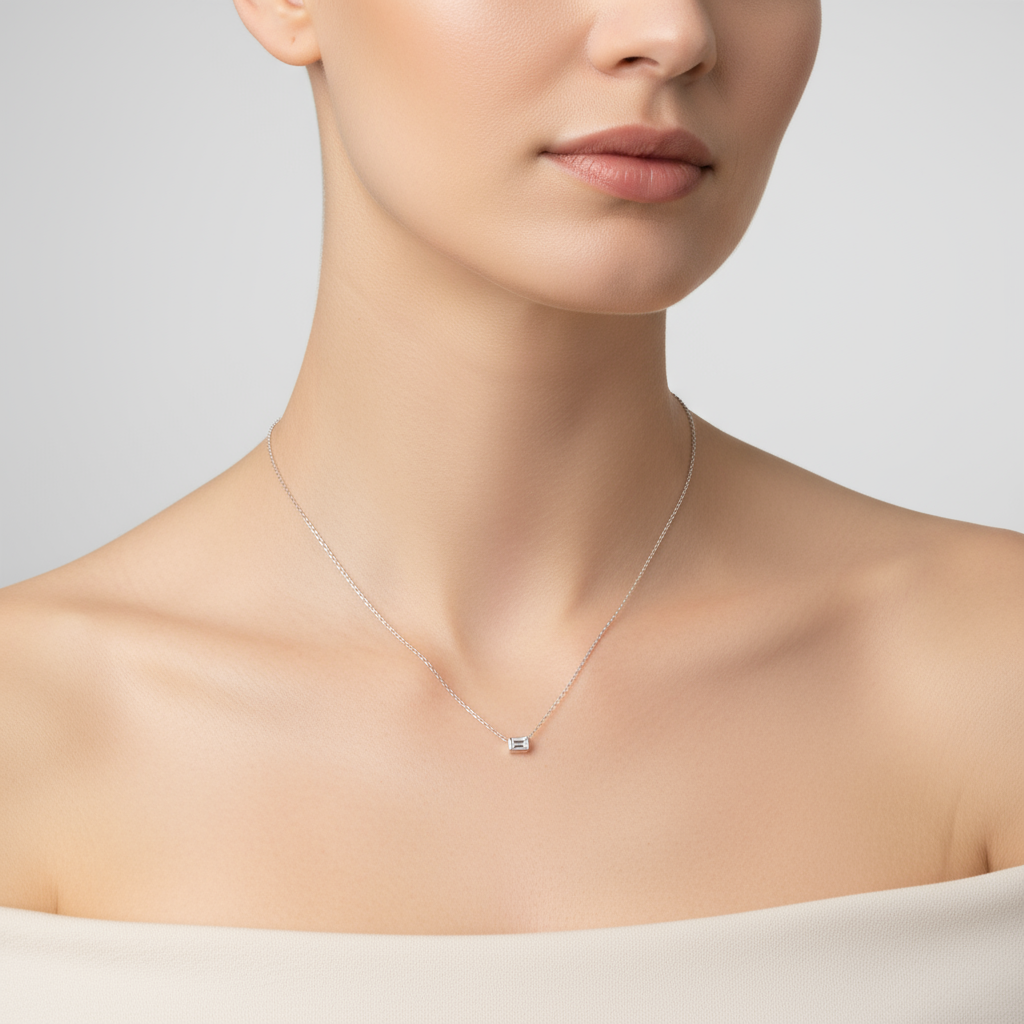 Female model wearing emerald-cut diamond solitaire necklace