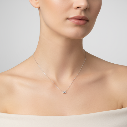 Female model wearing emerald-cut diamond solitaire necklace