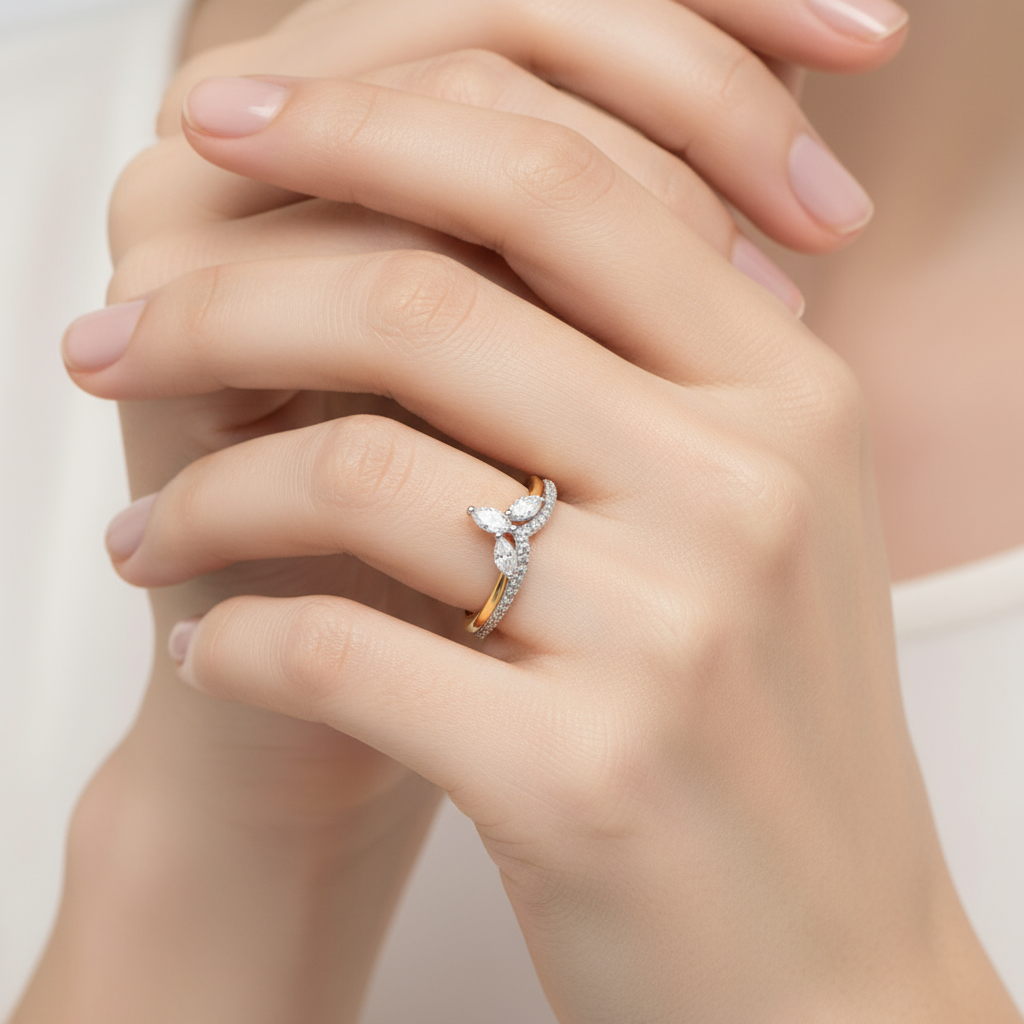 Female model wearing marquise and pear-shaped diamond cluster ring with chevron V-shaped band